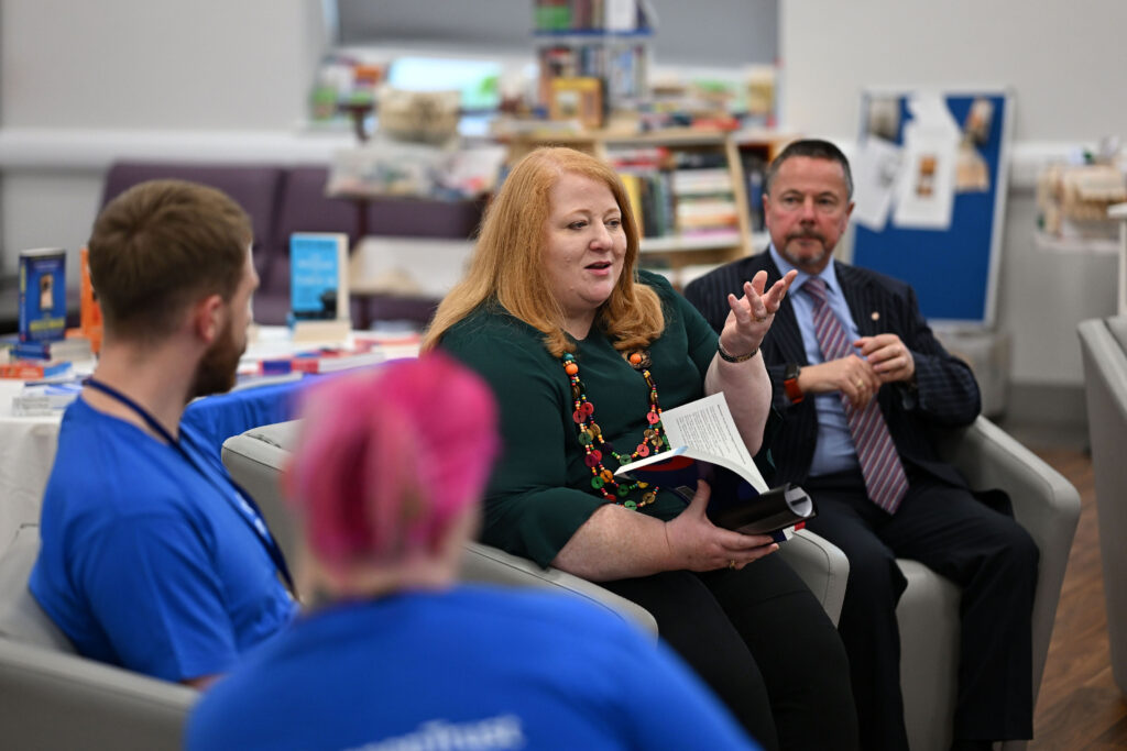 Justice Minister Naomi Long with young people at the Hydebank Wood library during Book Week NI 2026