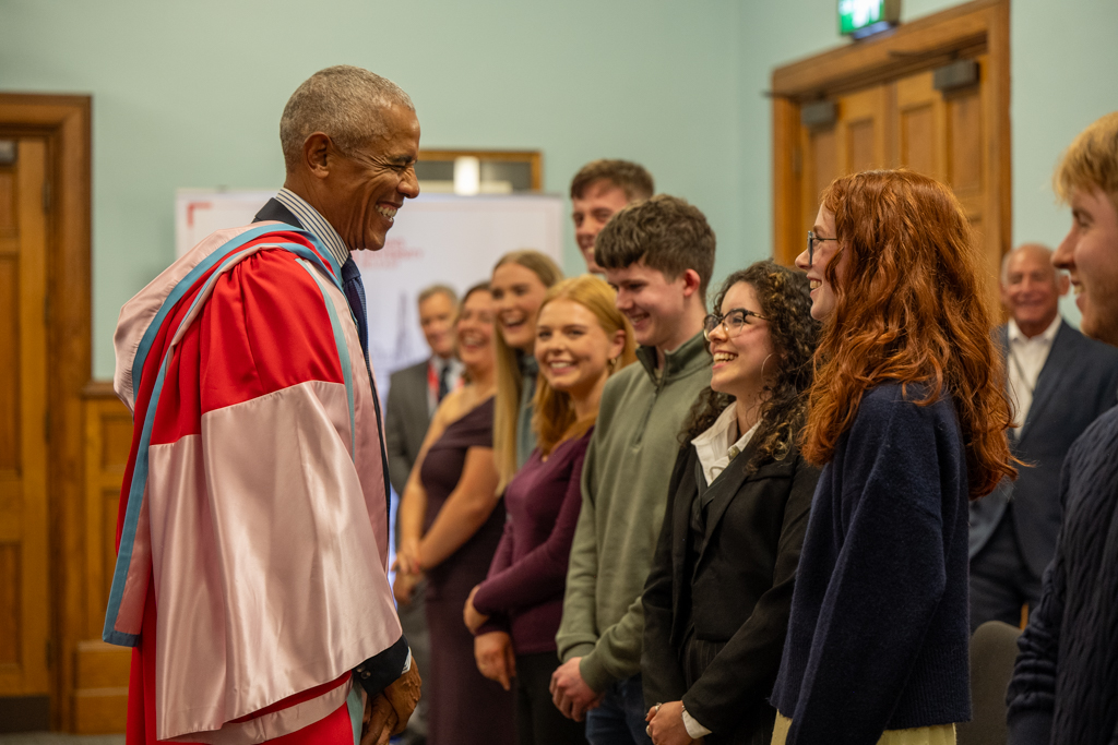 Barack Obama smiles while speaking with young people during his visit to Queen's University Belfast.