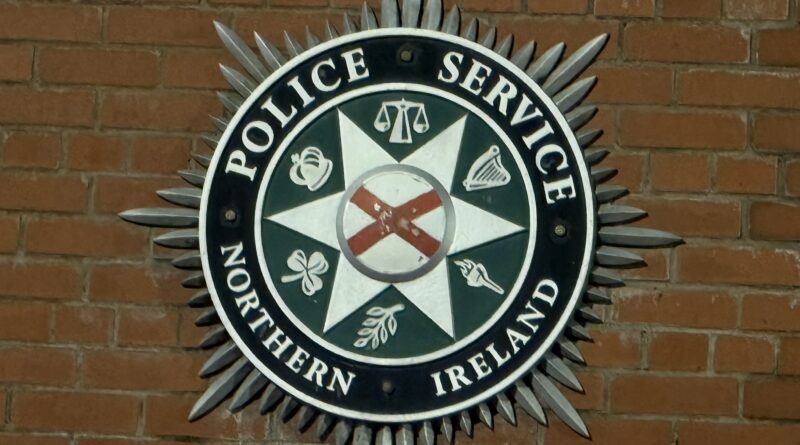 Police Service of Northern Ireland emblem on a brick wall